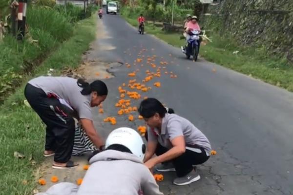 Sejumlah warga yang sedang memperebutkan bunga gumitir di tengah jalan beredar di media sosial